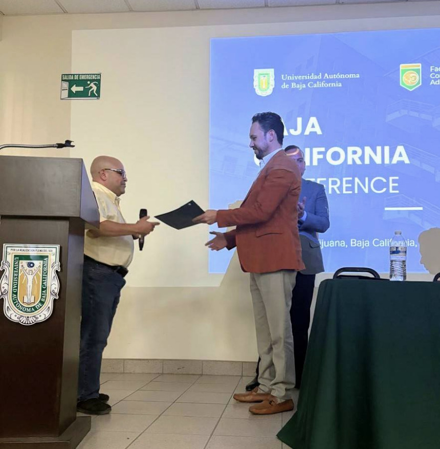 Marco Santelices recibiendo un reconocimiento de la UABC y la IEEE por su participación como ponente en la conferencia 2025.