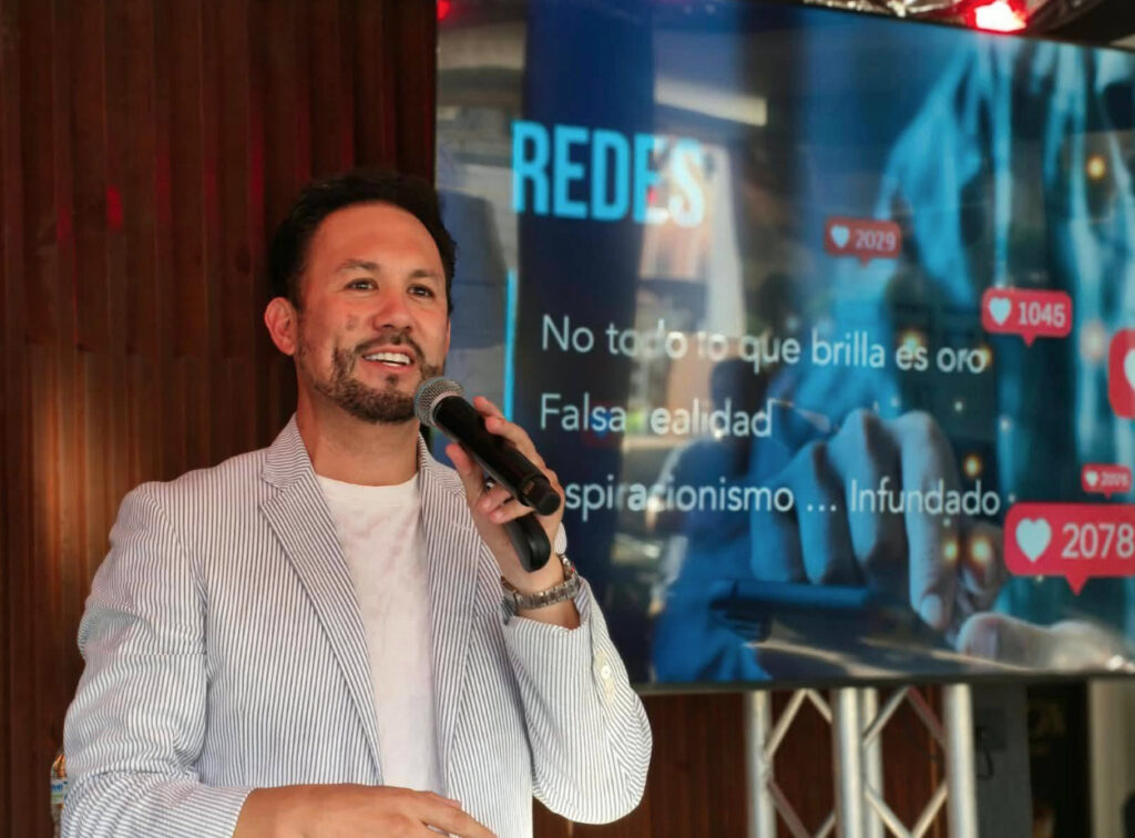 El empresario Marco Antonio Moreno Gómez Santelices hablando con un micrófono durante su conferencia sobre redes sociales y estrategia digital en la Feria de Emprendimientos Hecho en Tijuana.